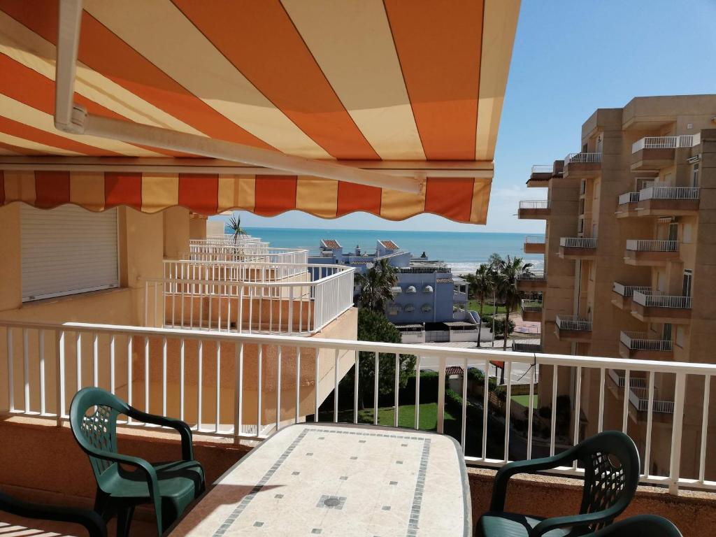 a balcony with a table and chairs and a view of the ocean at Parquemar III-IV Solo Familias!!! Serviplaya in Playa de Xeraco