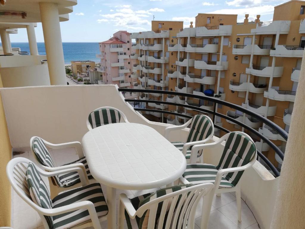 a balcony with a table and chairs and the ocean at Les Motes Solo Familias Serviplaya!!! in Playa de Xeraco