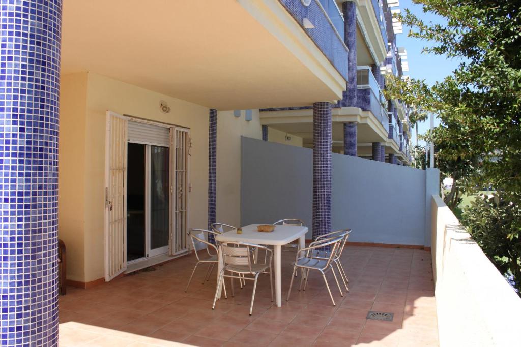 a table and chairs on a patio in a building at Delfines II Solo Familias Serviplaya in Playa de Xeraco