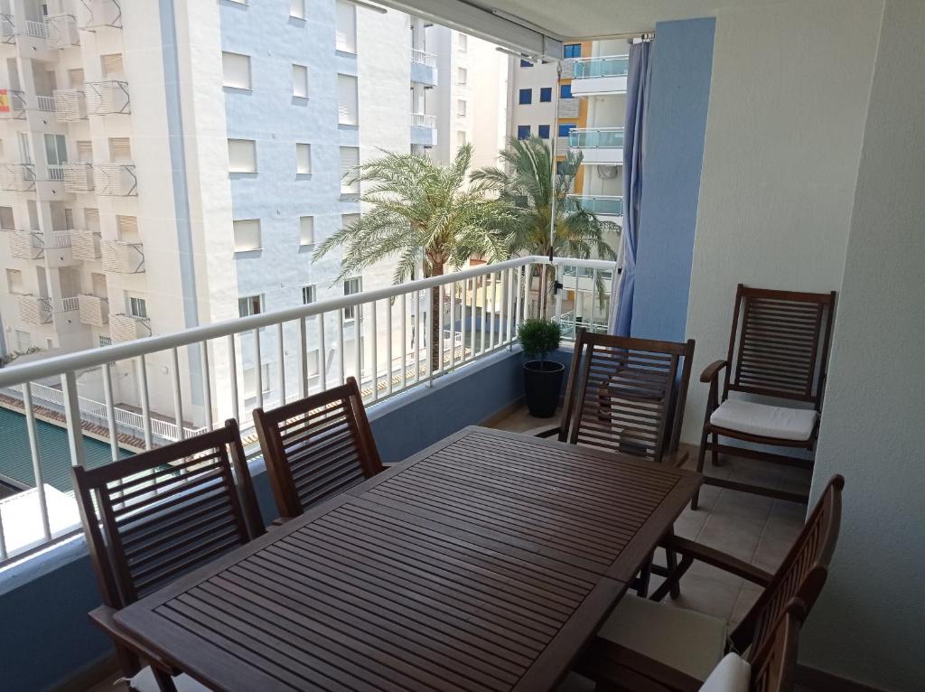 a balcony with a table and chairs on a balcony at Palmeras III Solo Familias Serviplaya!!! in Gandía