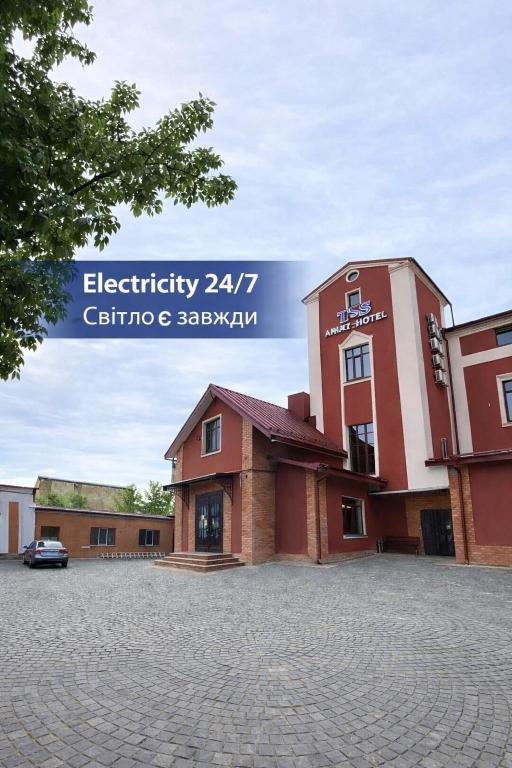 a building with a car parked in a parking lot at T&S Apart-Hotel in Chernivtsi