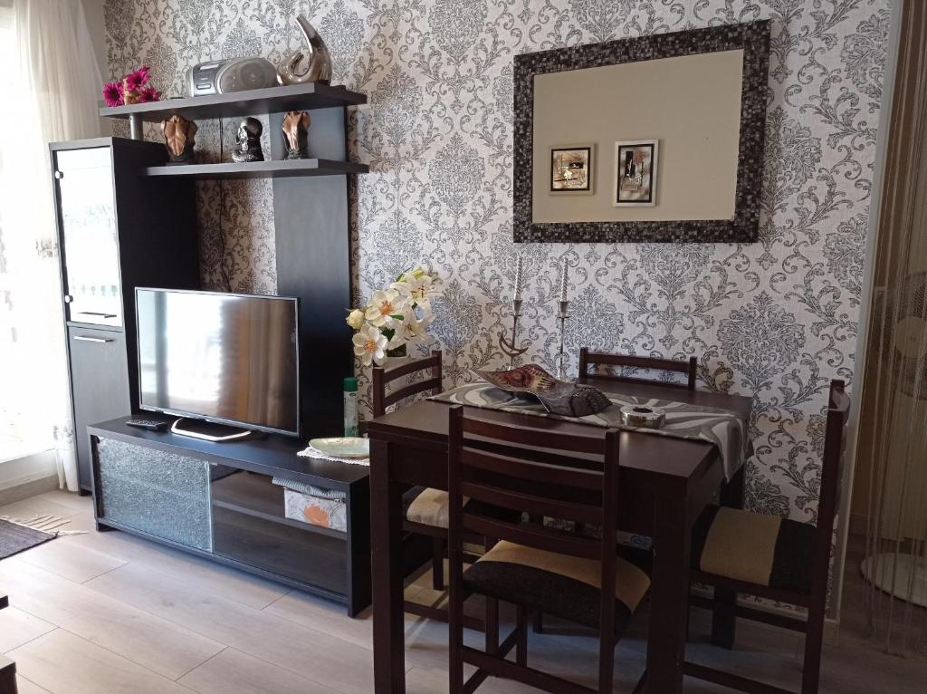 a dining room with a table and a television at Bali Solo Familias Serviplaya in Playa de Xeraco