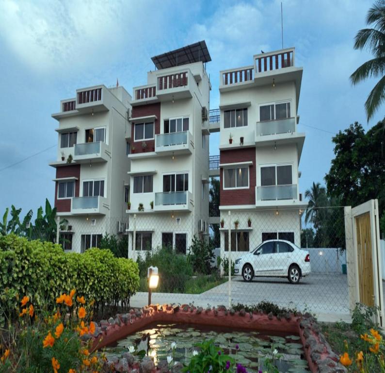 a white car parked in front of a building at Gold Mountain Wellness Resort in Tiruvannāmalai
