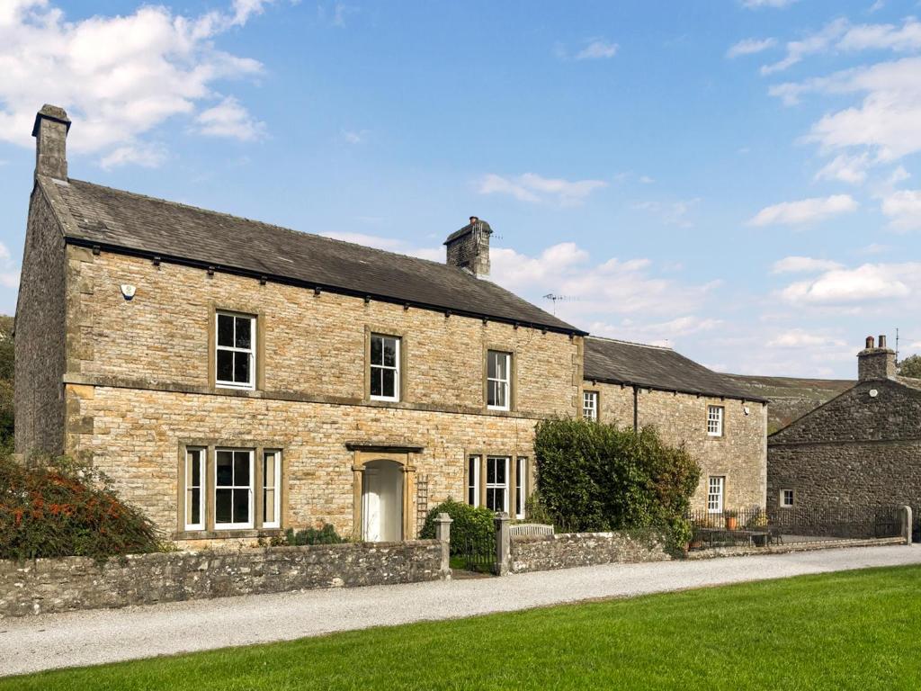an old stone house with a driveway at High Rylands in Arncliffe