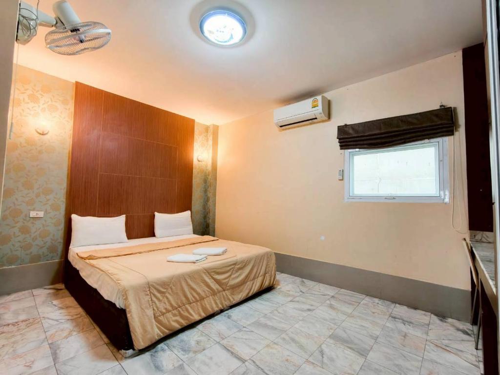 a bedroom with a bed and a window at Veerakit Grand Hotel Udon Thani in Udon Thani