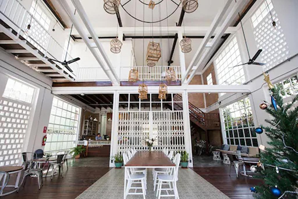 a large room with a table and chairs and a christmas tree at Memmoth Cafe & Hostel in Lampang in Lampang
