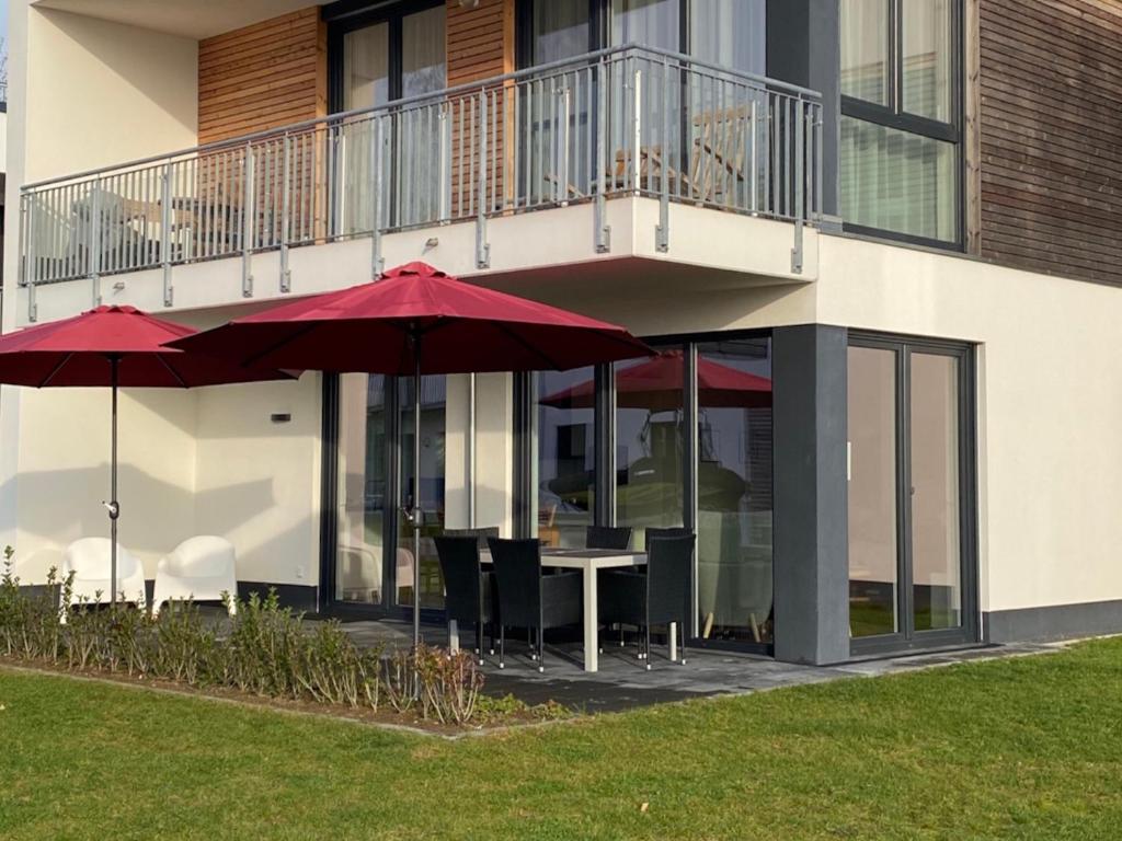 a patio with tables and umbrellas in front of a building at Hangar 19 Seebrise in Schwerin