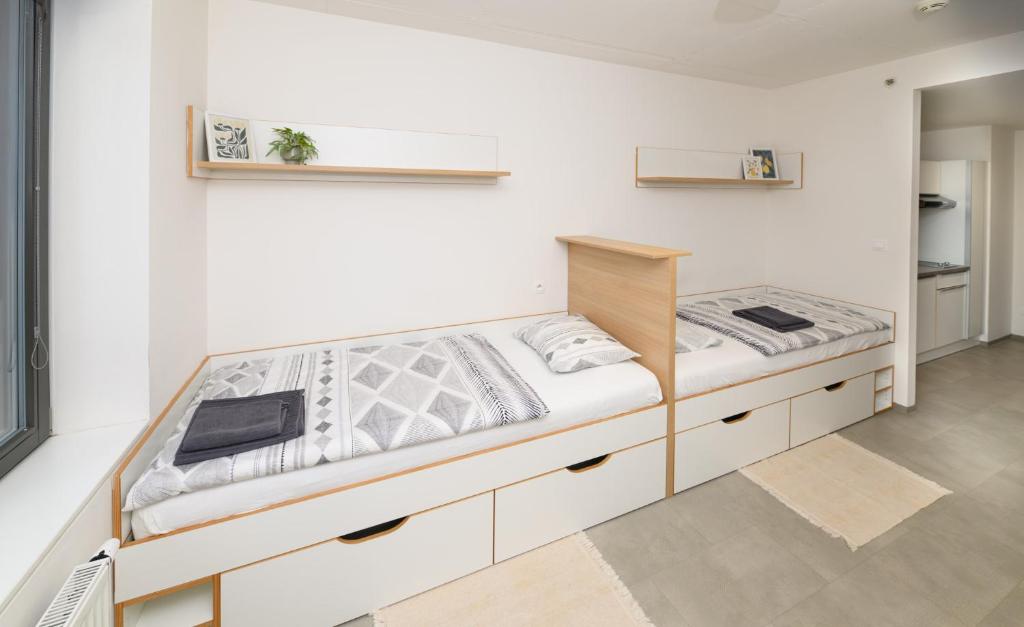 a bedroom with a large bed with white walls at Domeq FREE Parking, Gym, Co-working and Terrace in Komárov