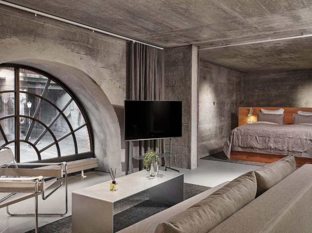 a bedroom with a bed and a couch and a tv at Ottilia Heritage in Copenhagen