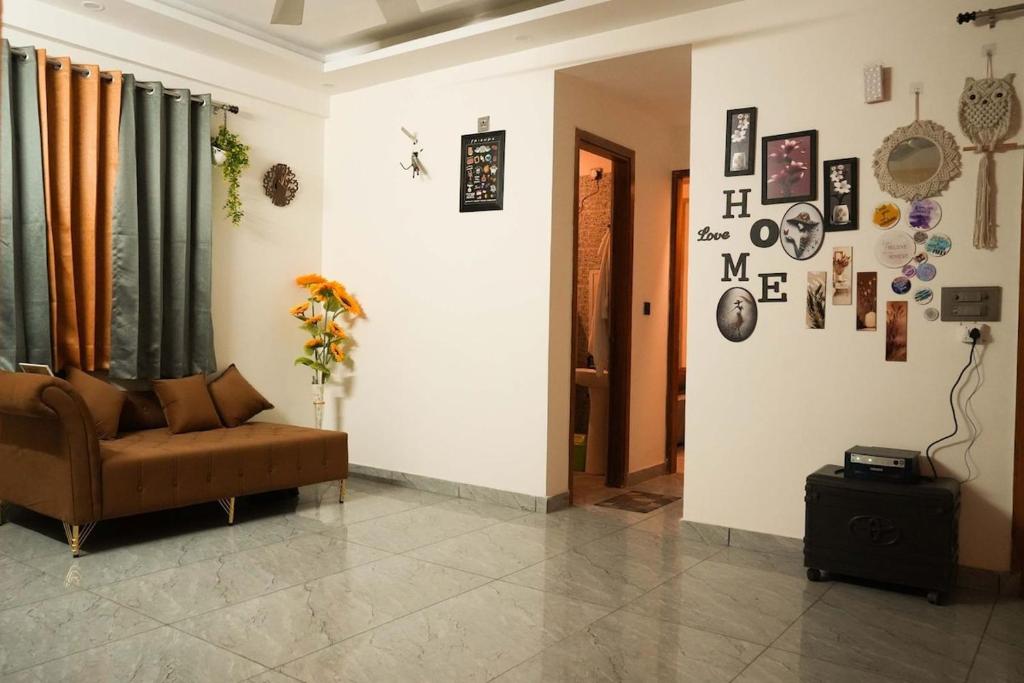 a living room with a couch and some pictures on the wall at Chill pad in Dehradun