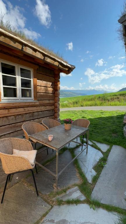 a table and chairs on a patio outside of a cabin at Gunhild-stugu in Skogbygd