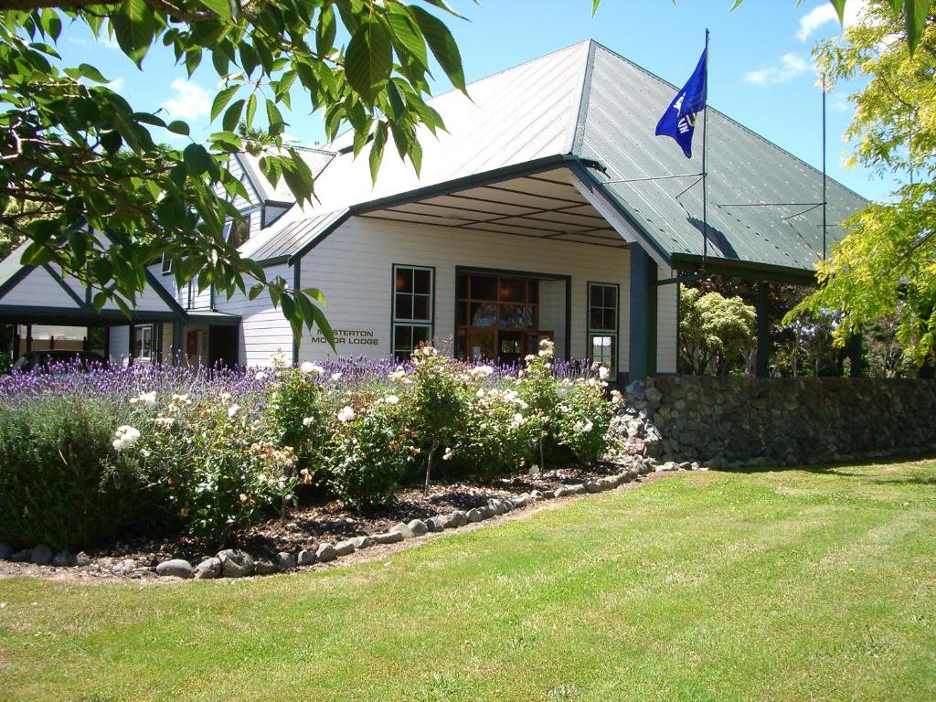 un edificio con bandera frente a un jardín en Masterton Motor Lodge, en Masterton