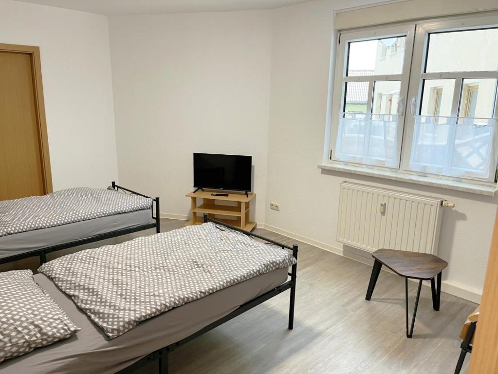 a room with three beds and a tv and a window at Monteurwohnung in Coswig in Coswig