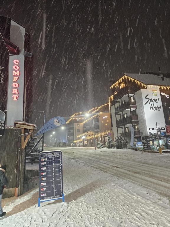 a snowy street with a sign in the snow at Private Suite at Comfort Bansko in Bansko