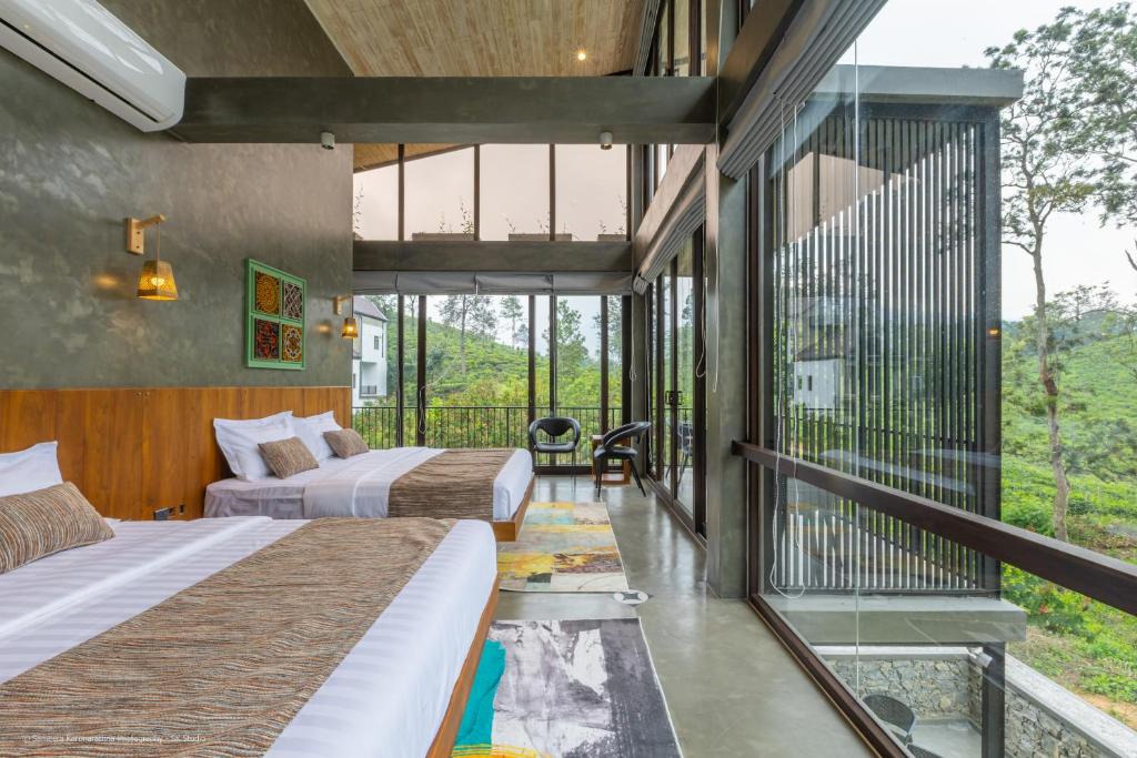 two beds in a room with a balcony at Sathkara Resort Ella in Ella