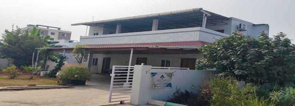 a house with a white gate in front of it at Kostha Suites in Anumalkudūru