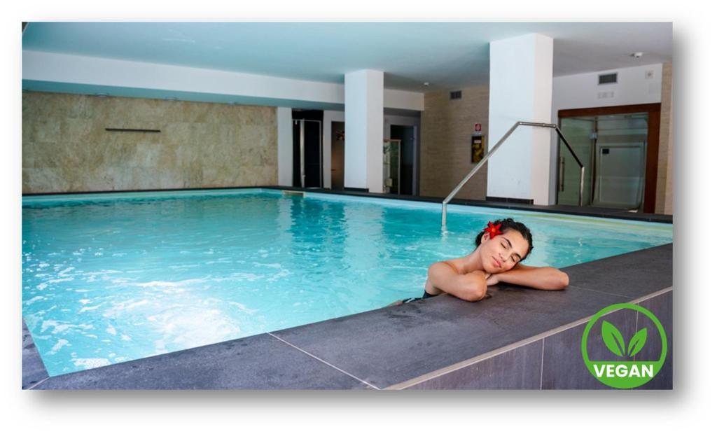 a young child laying in a swimming pool at Zenit Hotel in Giulianova