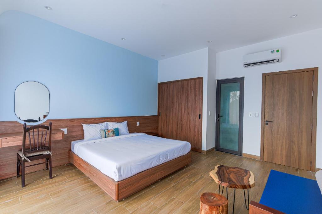 a bedroom with a bed and a desk and a chair at Cocohamlet Villa in Thanh Ðông (1)