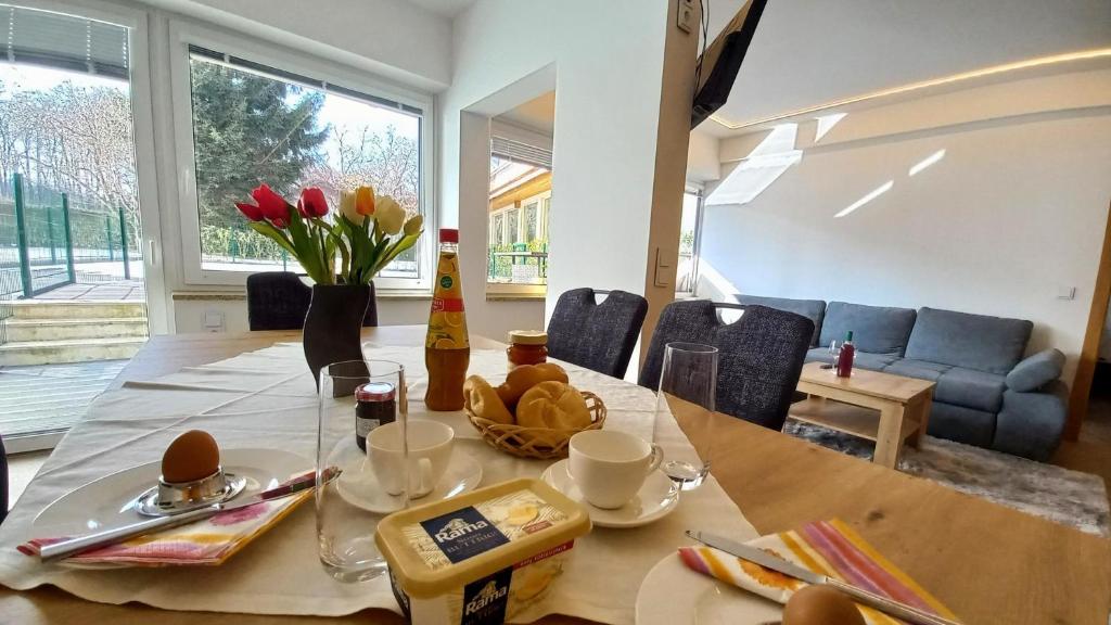 a dining room with a table with food and flowers on it at Luxus Terrassenappartement Berg & See 1 in Bodensdorf