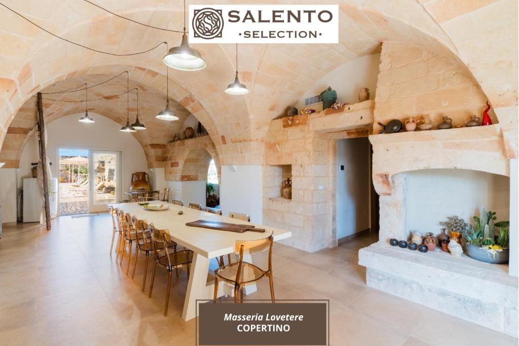 a kitchen with a table and a fireplace at Masseria Lovetere Rooms - Salento Selection in Copertino