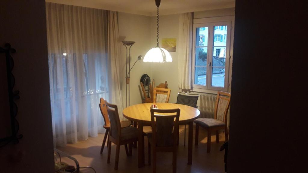 a dining room with a table and chairs and a window at Appenzellerland Schöne Wohnung in einem Wandergebiet in Teufen