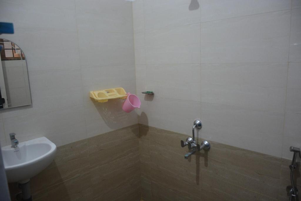 a bathroom with a sink and a toilet and a mirror at Durga Nivas in Kurnool