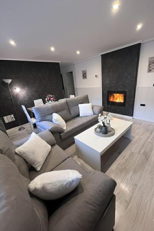 a living room with a couch and a fireplace at Living Canovas in Alcalá de Henares
