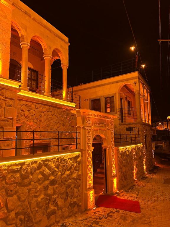 a stone building with an arch in front of it at night at Zümrütü Anka Cave in Ürgüp