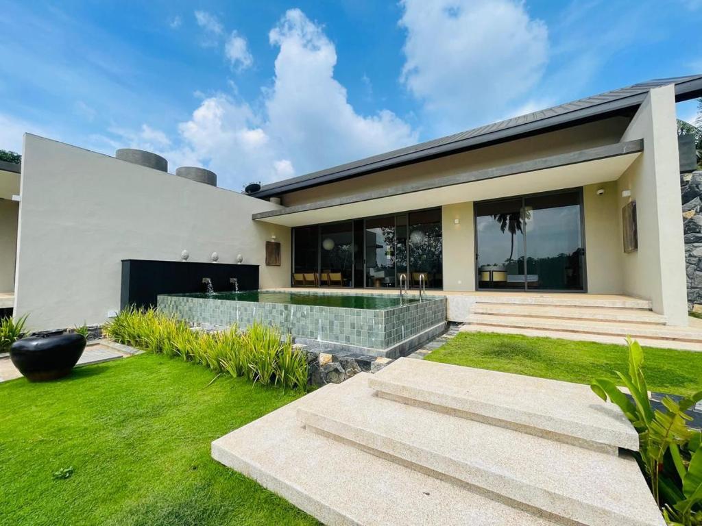 a modern house with a green lawn in front of it at Hansa Villa in Weligama