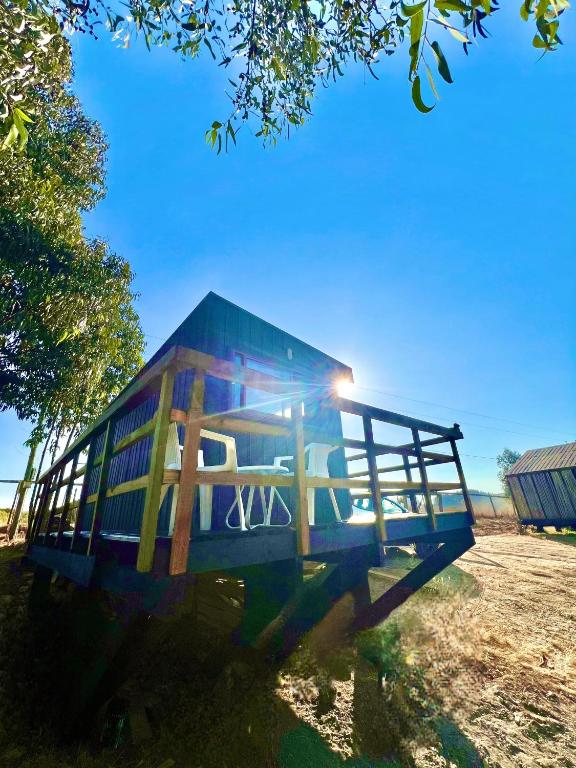 a blue barn with the sun shining on it at Tiny House Pangal in Pichilemu
