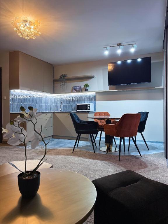 a kitchen and living room with a table and chairs at Villa Morska Perła in Rewal