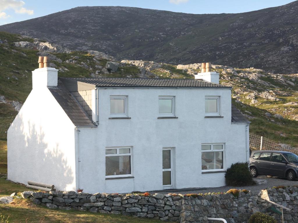 a white house with a stone wall at Tigh Mairi in Tarbert