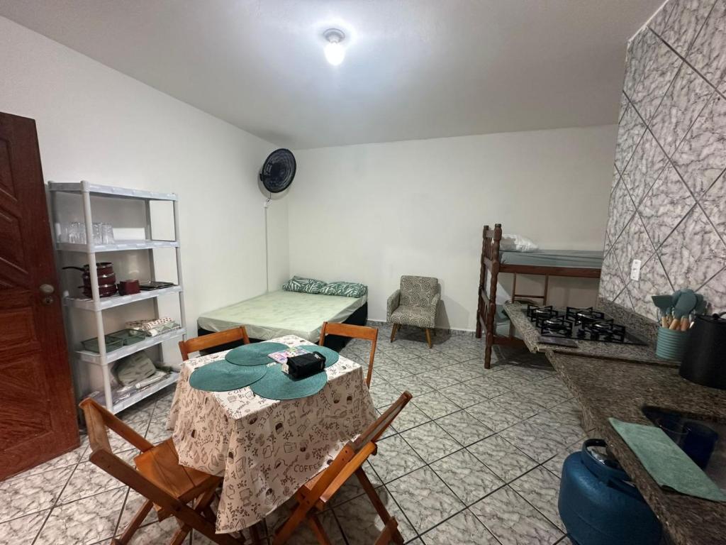 a room with a table and chairs in a room at Kitnet Estrela do Mar in Peruíbe