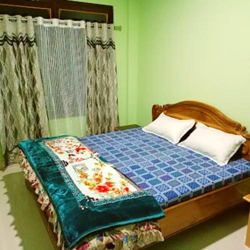 a bedroom with a bed with a blue comforter at LDR Homestay in Tawang