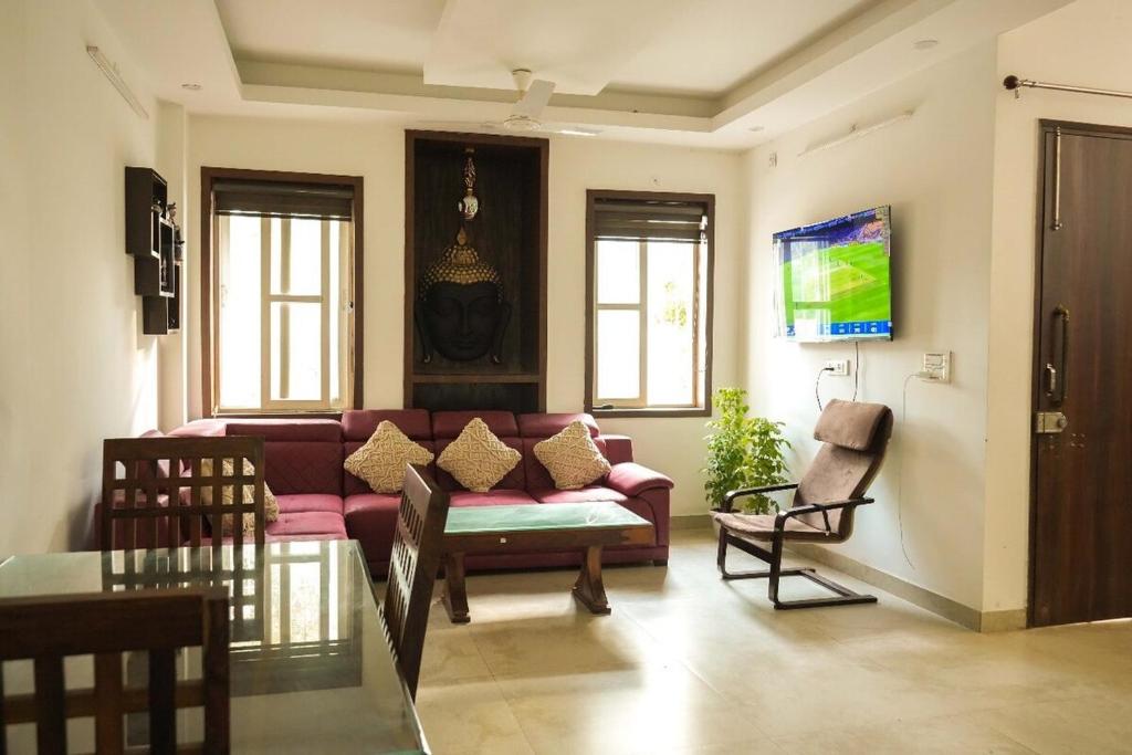 a living room with a couch and a tv at Echoes of Doon in Rājpur