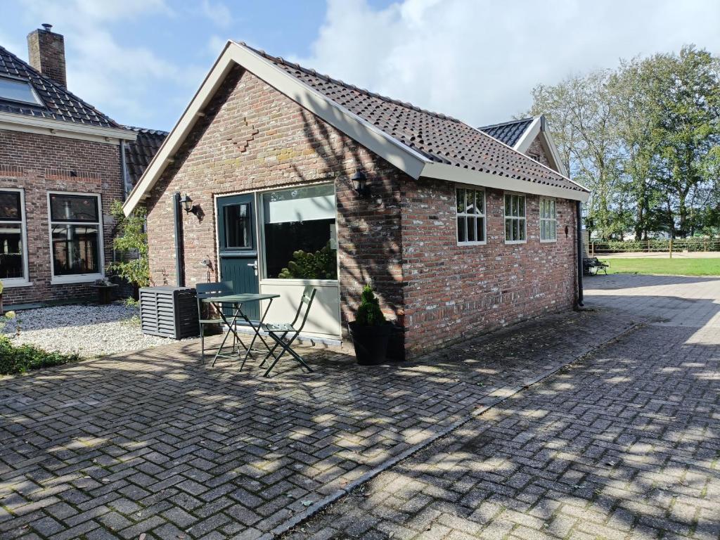 a brick building with a table outside of it at Theehus in Steggerda