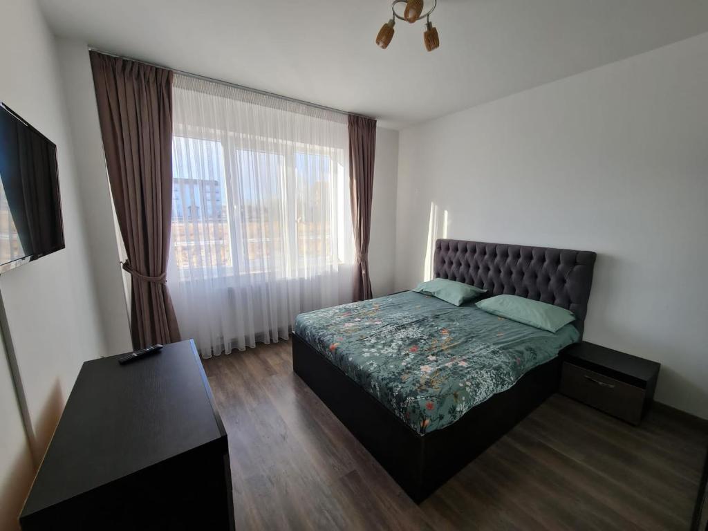 a bedroom with a bed and a large window at Rădăuți Residence 2 in Rădăuţi