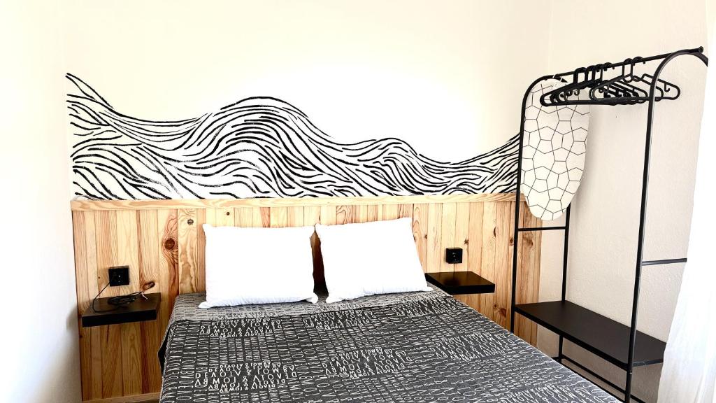 a bedroom with a bed with a black and white headboard at Apartamentos ÁBREME Y VERÁS in Arcos de la Frontera
