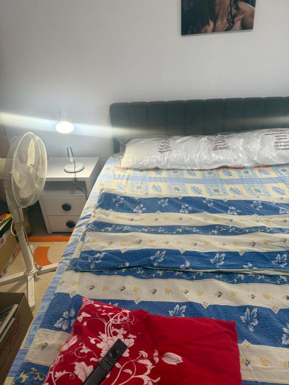 a bed with a blue and white quilt on it at Kay Borsa in Alba Iulia