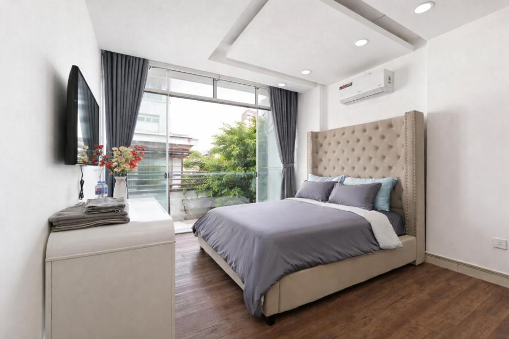 a bedroom with a large bed and a window at M Home Riverside in Ho Chi Minh City