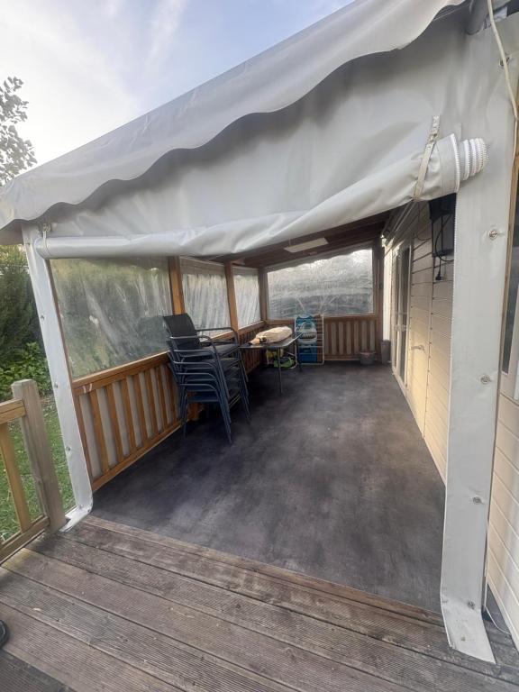 a screened porch with a table and chairs under a tent at mobilhome 5 personnes in Saint-Arnoult