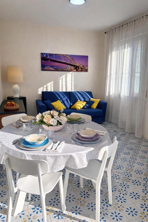 a living room with a table and a blue couch at Soleil Apartment - Zona Ospedale Pederzoli in Peschiera del Garda