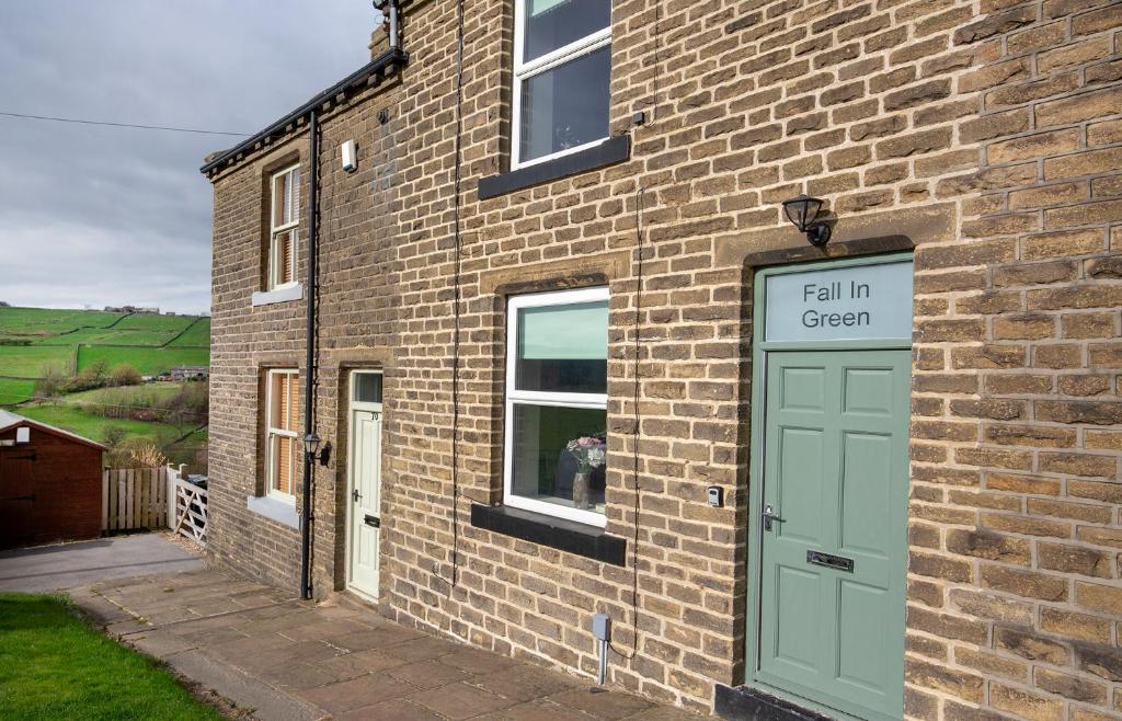 a brick building with a door and a fall in green at Fall in Green in Haworth