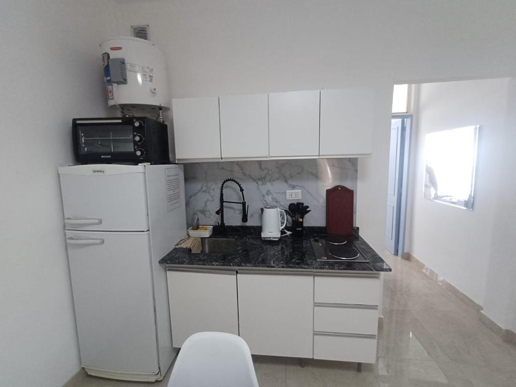 a kitchen with white cabinets and a white refrigerator at San bernardo ll in San Bernardo