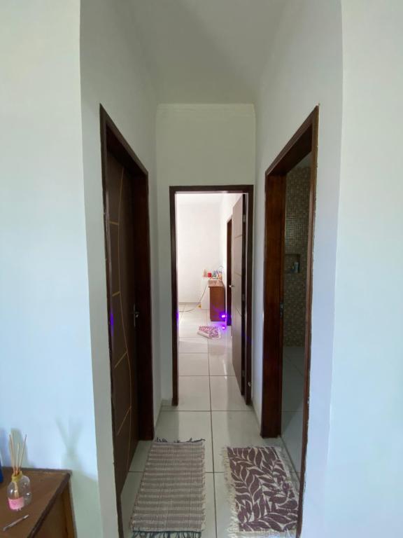 a hallway with two doors and a tile floor at Suíte na praia do amor in Conde