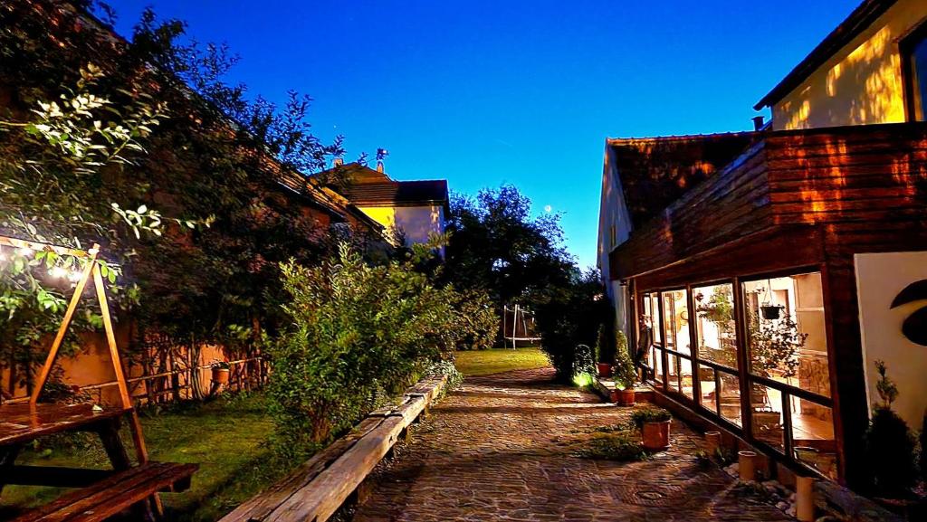 a cobblestone path next to a house and a building at Vila Studio Rasnov cu ciubar si sauna in Râşnov