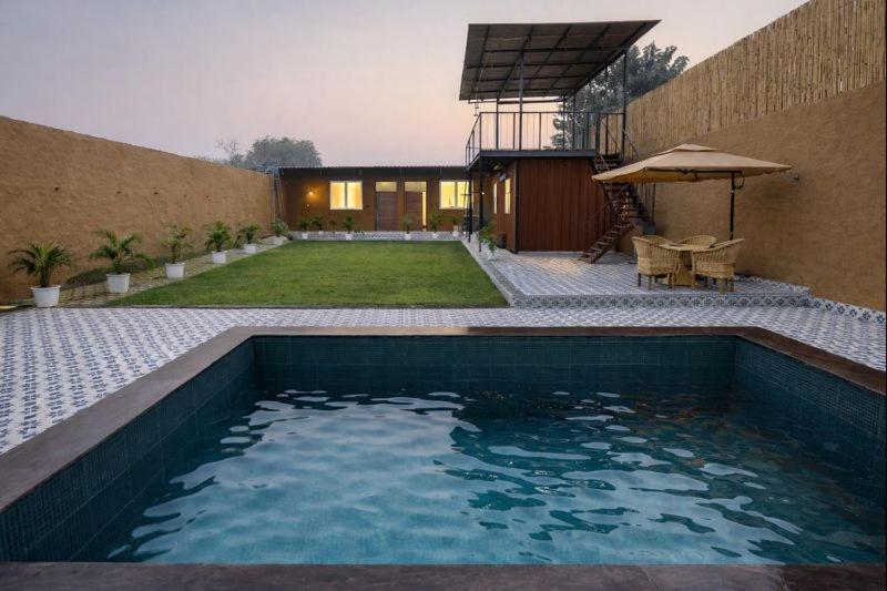 a swimming pool in the backyard of a house at Mud Meadows Peace and Tranquility Farm With Pool in Faridabad