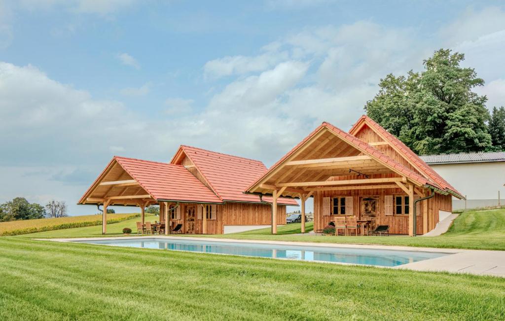 two houses with a pool in the grass at Chalet In Stainz in Stainz