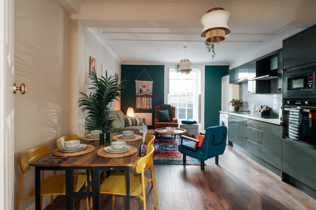a kitchen and living room with a table and chairs at Stylish Harbourfront Apartment in Torquay