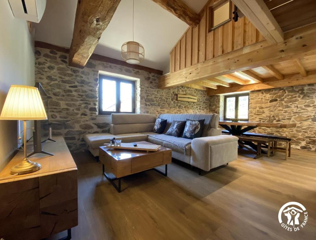 a living room with a couch and a table at Les pérics in Puyvalador